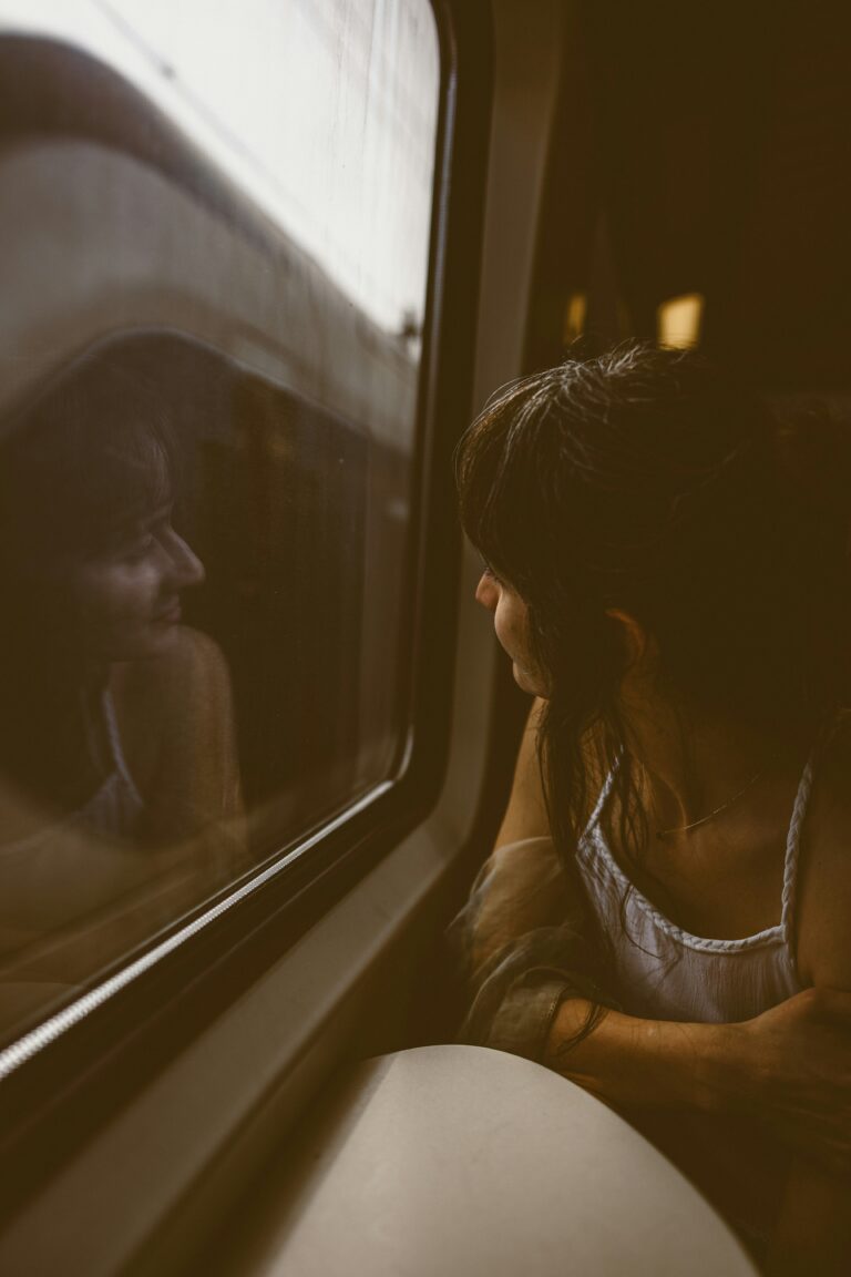 woman looking out of a train window on her way to court to secure compensation for her dental claim